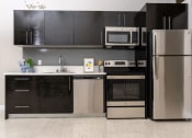 Thumbnail 2 of 16 - a kitchen with stainless steel appliances and black and white cabinets