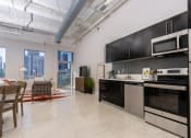 Thumbnail 1 of 16 - an open kitchen and living room with a view of the city