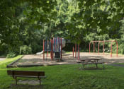 Thumbnail 79 of 82 - Playground surrounded by lush green landscaping at Trillium Apartments, Fairfax, 22031