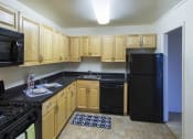 Thumbnail 52 of 82 - GOLD all-black appliances in an open kitchen space at Trillium Apartments, Virginia, 22031