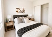 Thumbnail 23 of 31 - A bedroom with a large bed and a wooden headboard.