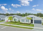 Thumbnail 4 of 37 - a group of white houses with palm trees in front of a street