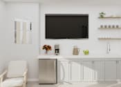 Thumbnail 8 of 14 - A white chair sits in front of a fridge and a television.