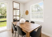 Thumbnail 15 of 31 - A dining room with a wooden table and chairs.