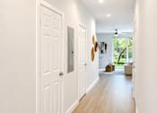 Thumbnail 12 of 31 - A hallway with white doors and a ceiling fan.