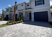 Thumbnail 1 of 31 - A modern house with a driveway in front.