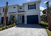 Thumbnail 7 of 31 - A modern two-story house with a driveway in front.