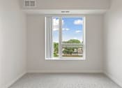 Thumbnail 15 of 44 - A room with a window showing a view of a residential area at Sonder Point 50+ Apartments, Brooklyn Center, MN, 55430