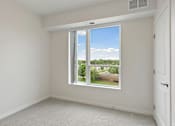 Thumbnail 16 of 44 - A room with a large window overlooking a residential area at Sonder Point 50+ Apartments, Brooklyn Center, 55430