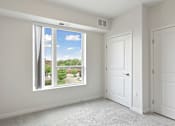 Thumbnail 17 of 44 - A room with a large window overlooking a residential area at Sonder Point 50+ Apartments, Brooklyn Center, MN