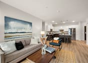 Thumbnail 5 of 19 - a living room with a couch and a table at The Landing at Amber Fields Apartments, Minnesota, 55068