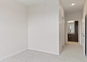 Thumbnail 22 of 44 - A white room with a carpeted floor and a doorway leading to another room at Sonder Point 50+ Apartments, Minnesota