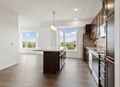 Thumbnail 25 of 44 - A modern kitchen with dark wood cabinets and a central island at Sonder Point 50+ Apartments, Brooklyn Center
