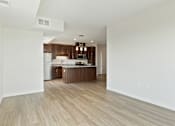 Thumbnail 6 of 44 - A kitchen with wooden floors and white walls at Sonder Point 50+ Apartments, Brooklyn Center