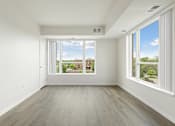 Thumbnail 10 of 44 - A large empty room with a view of the outside through the windows at Sonder Point 50+ Apartments, Brooklyn Center, 55430