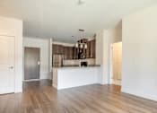 Thumbnail 10 of 41 - a kitchen and living room with hardwood floors and white walls at Sonder House, Brooklyn Center, MN, 55430