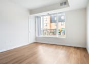 Thumbnail 9 of 44 - a bedroom with a large window and hardwood floors at Sonder Point 50+ Apartments, Minnesota, 55430
