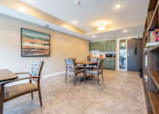 Thumbnail 38 of 44 - a dining area with a table and chairs and a kitchen in the background at Sonder Point 50+ Apartments, Minnesota, 55430
