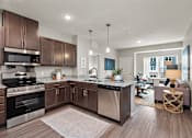 Thumbnail 7 of 40 - A modern kitchen with dark wood cabinets and stainless steel appliances.at Decatur Landing I & II, Minnesota, 55445