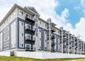 Thumbnail 30 of 33 - a large apartment building with balconies and a blue sky in the background at EastGate Apartments, Rochester, MN, 55904