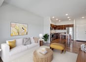 Thumbnail 1 of 33 - A modern living room with a white sofa and a yellow ottoman at EastGate Apartments, Minnesota