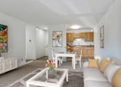 Thumbnail 6 of 21 - a living room with a couch and a table and a kitchen at Humboldt Senior 55+ Apartments, Saint Paul