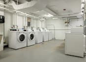 Thumbnail 15 of 21 - a row of washing machines and dryers in a laundry room at Humboldt Senior 55+ Apartments, Minnesota, 55107