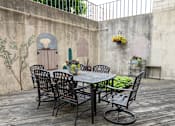 Thumbnail 14 of 21 - a patio with a table and chairs against a wall at Humboldt Senior 55+ Apartments, Saint Paul, MN