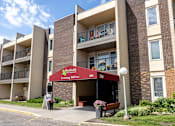 Thumbnail 18 of 21 - an apartment building with a red awning in front of it at Humboldt Senior 55+ Apartments, Minnesota