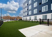 Thumbnail 19 of 19 - the yard of an apartment building with a green lawn and a fence at The Landing at Amber Fields Apartments, Rosemount