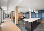 Thumbnail 15 of 19 - A long hallway with a kitchen area at the end. at The Landing at Amber Fields Apartments, Rosemount, MN