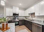 Thumbnail 2 of 19 - a kitchen with white cabinets and granite counter tops and stainless steel appliances at The Landing at Amber Fields Apartments, Rosemount, MN