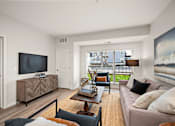 Thumbnail 10 of 19 - A living room with a brown sofa and a wooden coffee table at The Landing at Amber Fields Apartments, Minnesota, 55068
