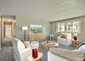 Thumbnail 1 of 14 - A living room with a white couch, a red lamp, and a painting on the wall at Northtown Village Apartments, Minnesota