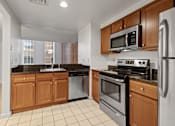 Thumbnail 3 of 21 - A kitchen with a black granite countertop and stainless steel appliances. at Parkside Apartments, St. Paul