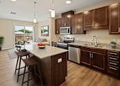 Thumbnail 10 of 27 - a kitchen with wooden cabinets and a marble counter top at The Quill 55+ Apartments, Hastings, MN, 55033