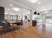 Thumbnail 32 of 44 - A modern dining room with a wooden table and chairs at Sonder Point 50+ Apartments, Brooklyn Center, MN, 55430