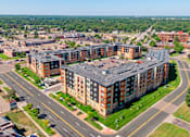 Thumbnail 42 of 44 - an aerial view of an apartment complex with a large building with a gray roof at Sonder Point 50+ Apartments, Brooklyn Center, Minnesota