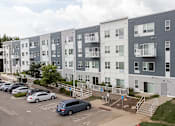 Thumbnail 48 of 51 - an image of an apartment building with cars parked in a parking lot at Technology Park Apartments, Rochester, 55901