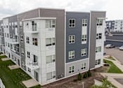 Thumbnail 46 of 51 - an aerial view of an apartment building with green grass and a parking lot at Technology Park Apartments, Rochester, MN, 55901