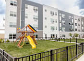 Thumbnail 51 of 51 - a playground in the middle of an apartment building with a slide at Technology Park Apartments, Minnesota