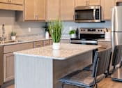 Thumbnail 4 of 51 - a kitchen with a large island and stainless steel appliances at Technology Park Apartments, Minnesota