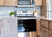 Thumbnail 6 of 51 - a modern kitchen with stainless steel appliances and white cabinets at Technology Park Apartments, Rochester, Minnesota
