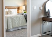 Thumbnail 12 of 51 - a bedroom with a bed and a nightstand and a mirror at Technology Park Apartments, Rochester