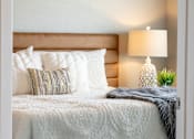 Thumbnail 9 of 51 - a bedroom with a bed and pillows and a lamp at Technology Park Apartments, Minnesota, 55901