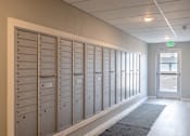 Thumbnail 23 of 51 - a row of lockers in a hallway with an exit door at Technology Park Apartments, Rochester, Minnesota