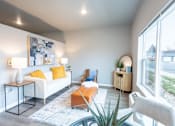 Thumbnail 31 of 51 - a living room with a couch and a coffee table and a large window at Technology Park Apartments, Rochester, Minnesota
