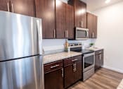 Thumbnail 25 of 51 - a kitchen with stainless steel appliances and wooden cabinets at Technology Park Apartments, Rochester