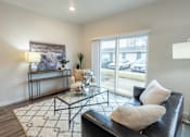 Thumbnail 37 of 51 - a living room with a black leather couch and a glass coffee table at Technology Park Apartments, Rochester, 55901