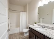 Thumbnail 45 of 51 - a bathroom with a sink toilet and shower and a mirror at Technology Park Apartments, Rochester, Minnesota
